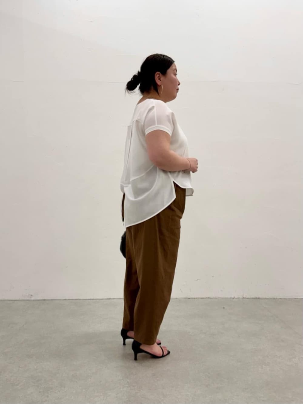 ブラック系のボストンバッグ、ホワイト系のシャツ/ブラウス、ブラウン系のその他パンツを着用したレディースの春コーディネートの5枚目の写真