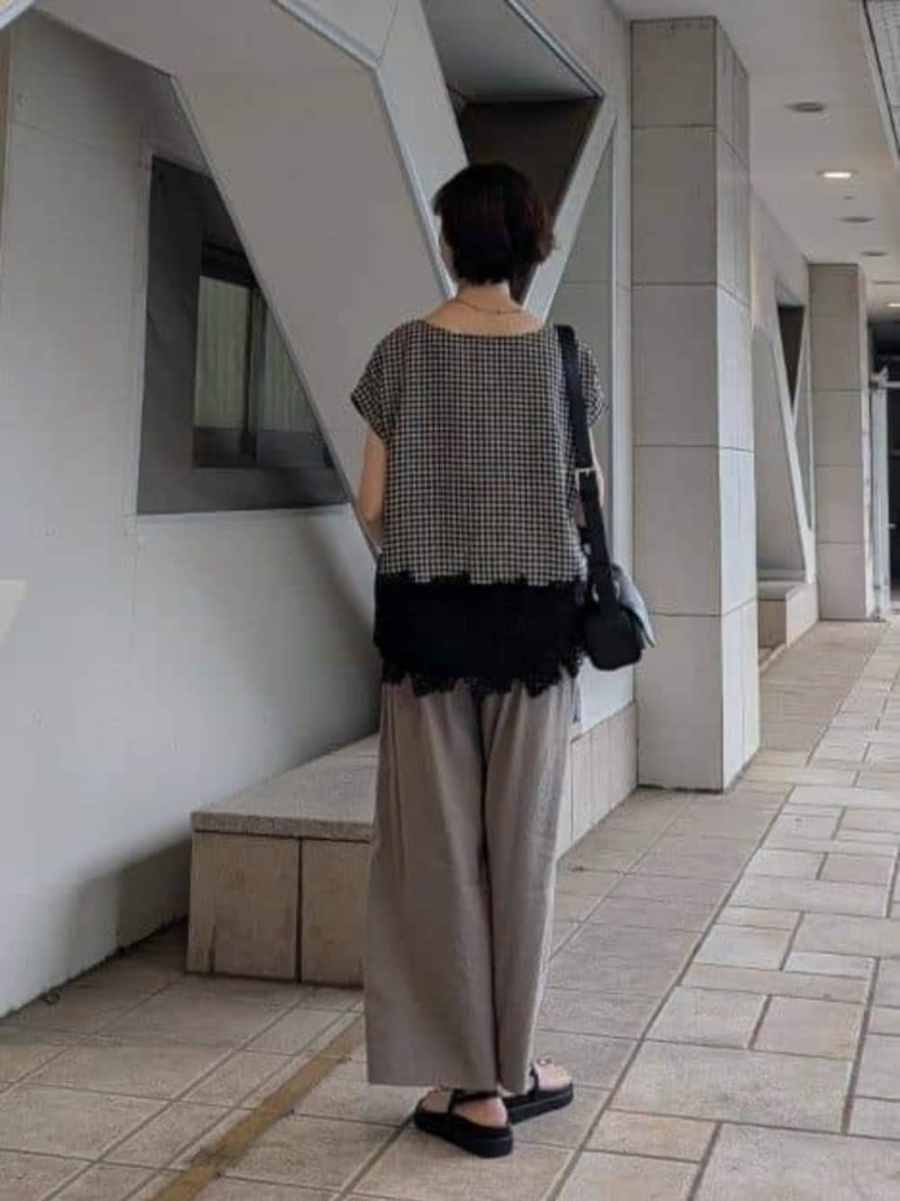 ブラック系のサンダル、ブラック系のシャツ/ブラウス、グレー系のその他パンツを着用したレディースの春コーディネートの3枚目の写真