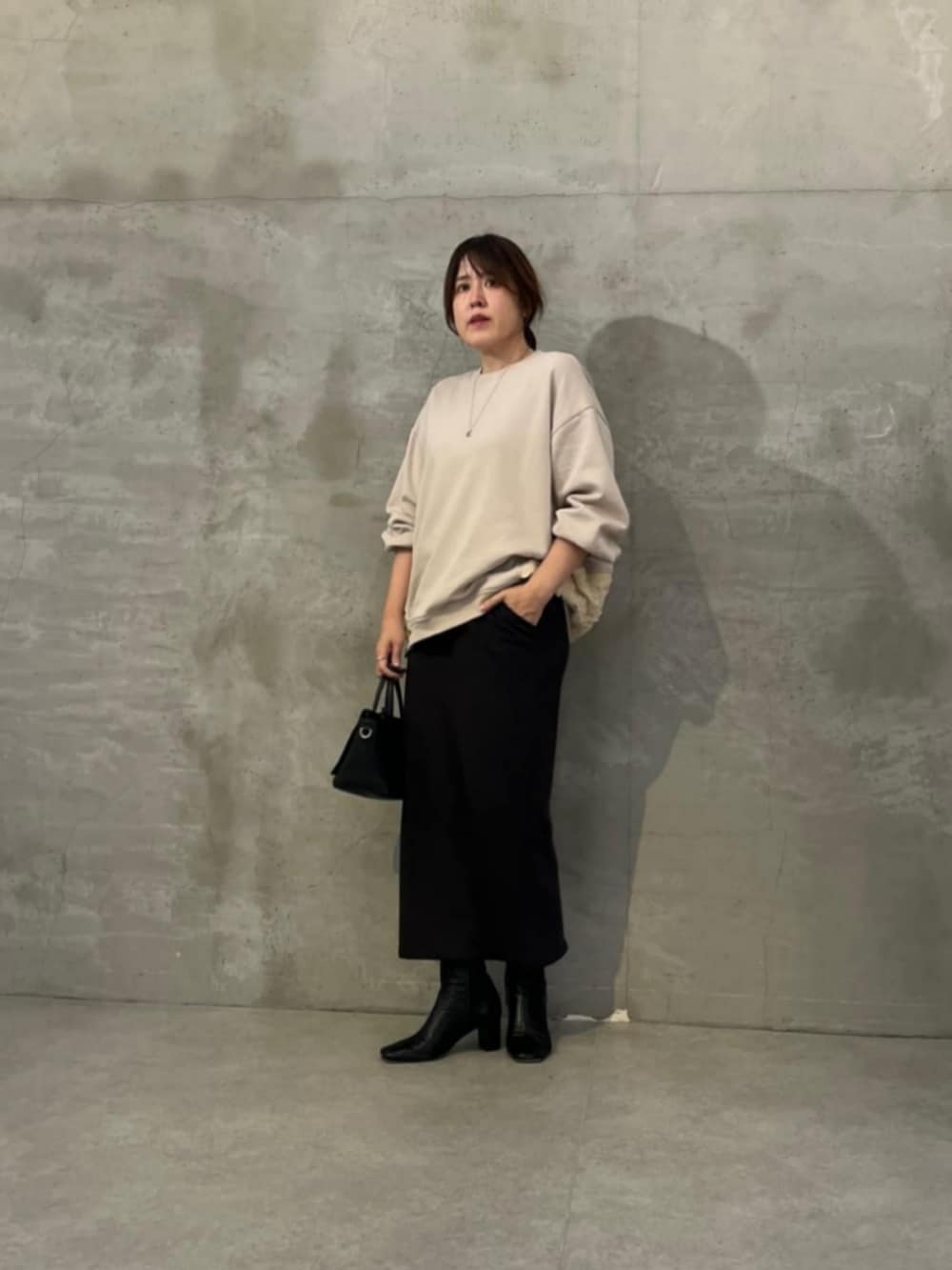 ブラック系のハンドバッグ、ホワイト系のTシャツ/カットソーを着用したレディースの秋コーディネートの6枚目の写真