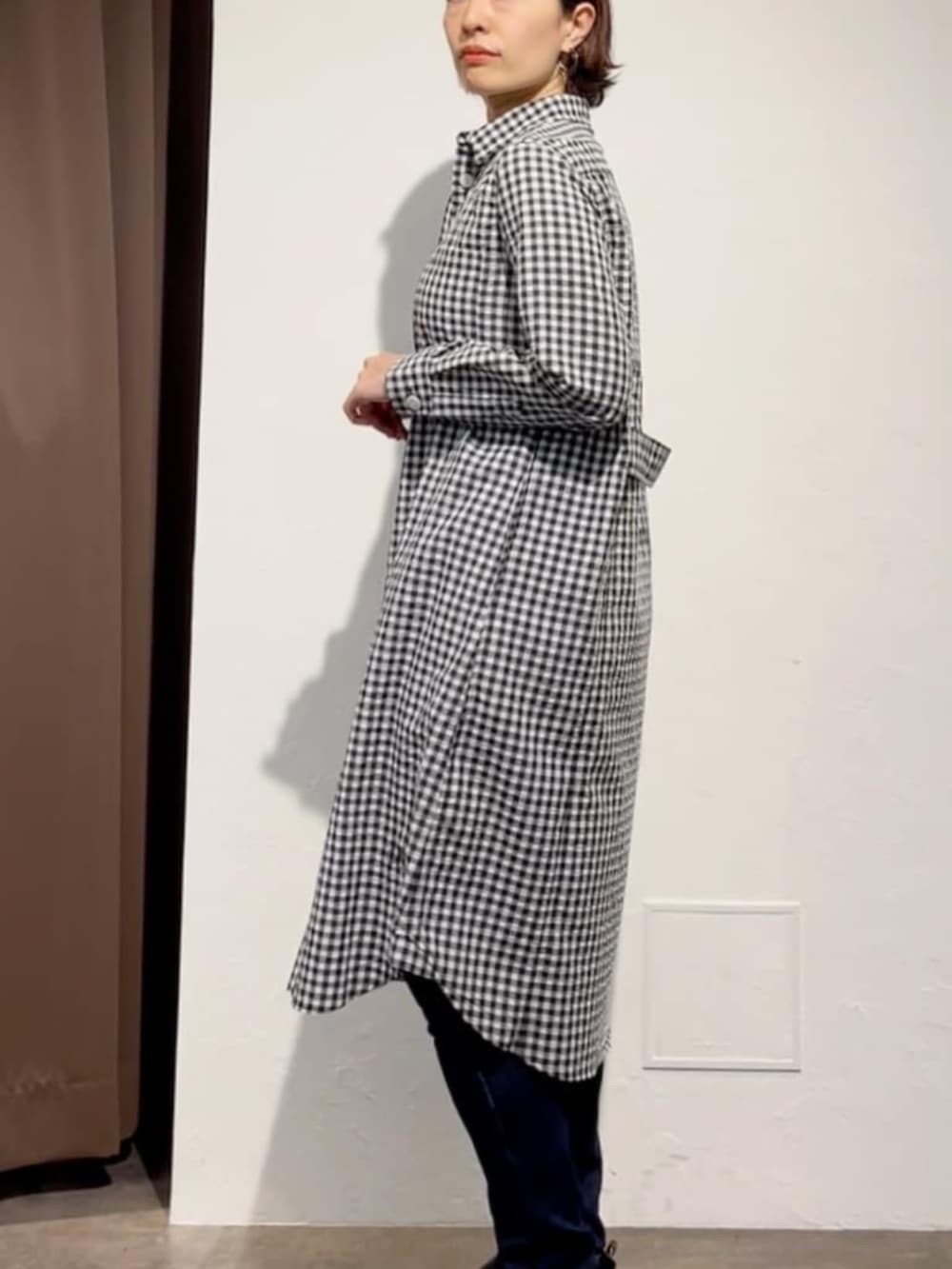 ブルー系のデニムパンツ、ブラック系のワンピース、ホワイト系のトートバッグを着用したレディースの春コーディネートの6枚目の写真