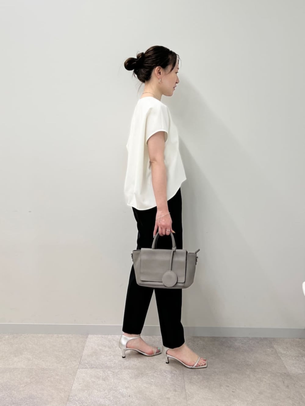 グレー系のハンドバッグ、ブラック系のその他パンツ、ホワイト系のシャツ/ブラウスを着用したレディースの春コーディネートの3枚目の写真
