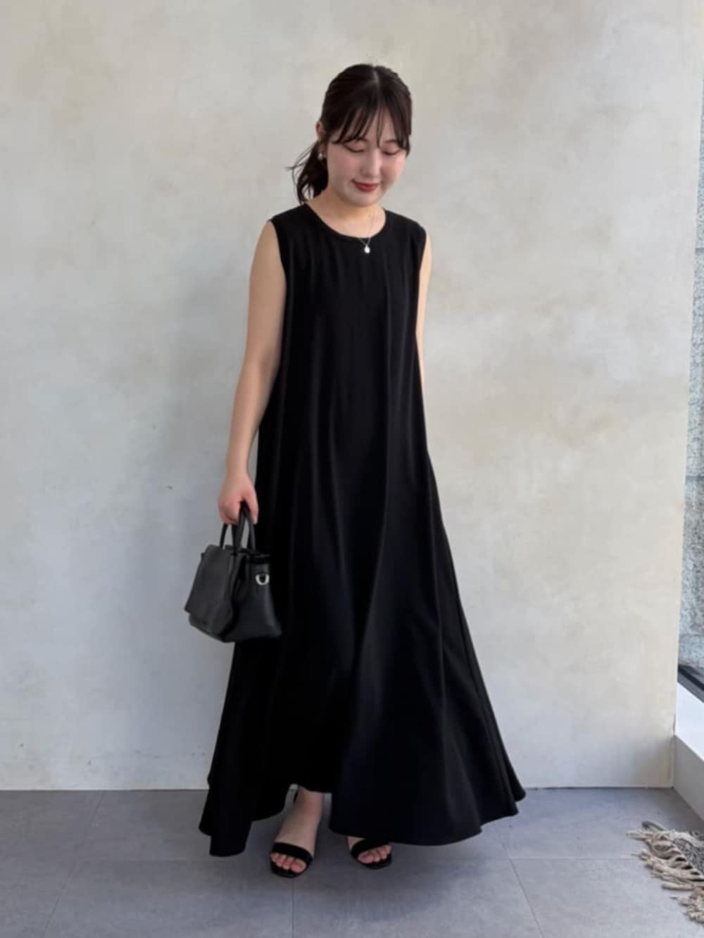 ブラック系のワンピース、ベージュ系のテーラードジャケットを着用したレディースの春コーディネートの7枚目の写真