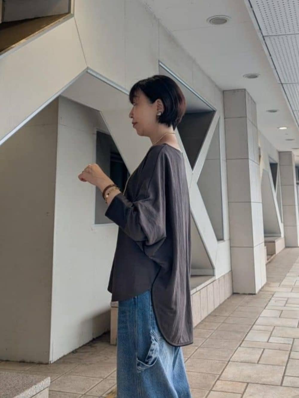 ブラック系のボストンバッグ、ブルー系のその他パンツ、ブラウン系のTシャツ/カットソーを着用したレディースの夏コーディネートの4枚目の写真