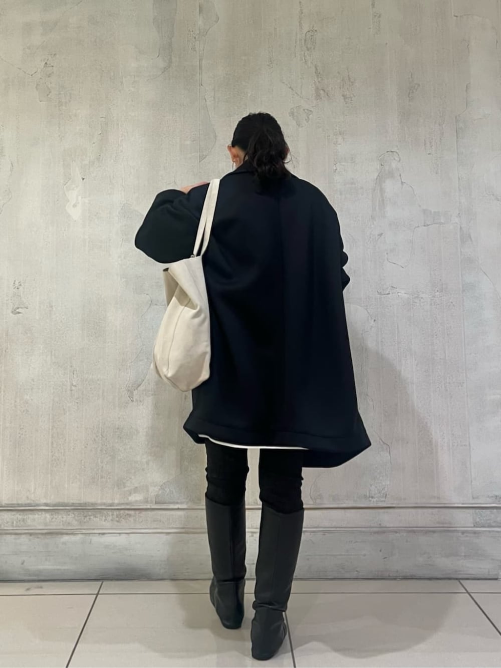 ブルー系のTシャツ/カットソー、ブラック系のデニムパンツ、ブラック系のピーコートを着用したレディースの冬コーディネートの6枚目の写真