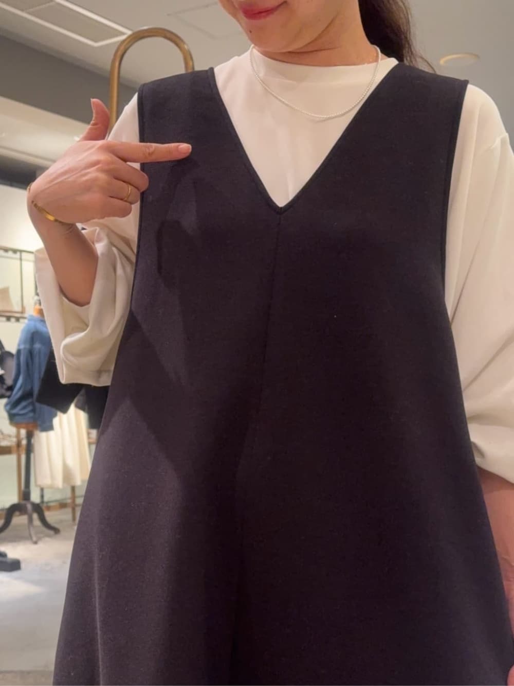 ホワイト系のシャツ/ブラウス、ブラック系のブーツ、ブラック系のジャンパースカートを着用したレディースの冬コーディネートの3枚目の写真