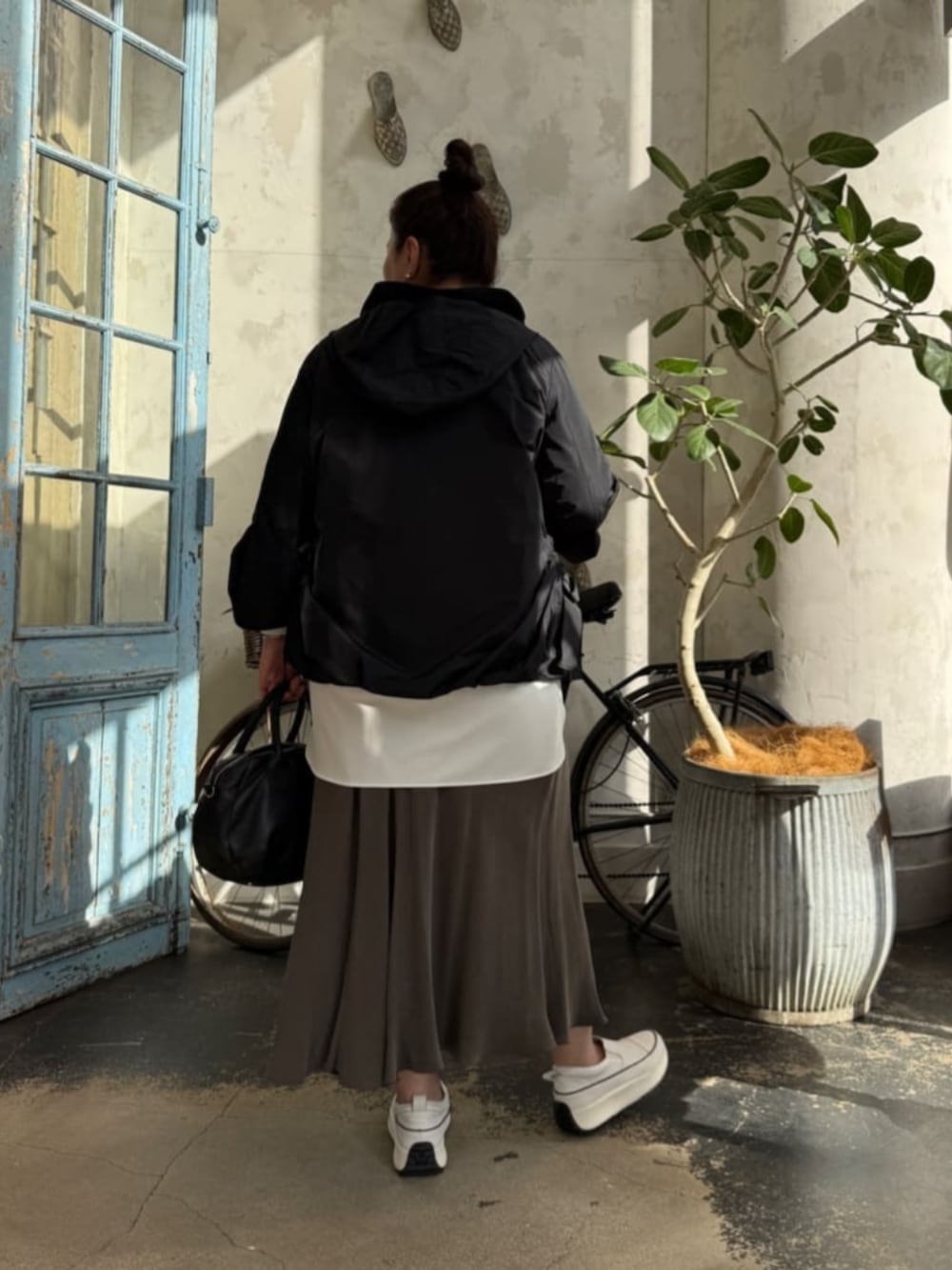 グリーン系のスカート、ブラック系のボストンバッグ、ホワイト系のシャツ/ブラウスを着用したレディースの冬コーディネートの3枚目の写真