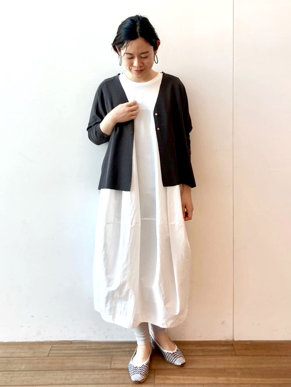 ホワイト系のワンピース、ブラック系のカーディガン/ボレロ、グレー系のその他パンツを着用したレディースの春コーディネートの2枚目の写真