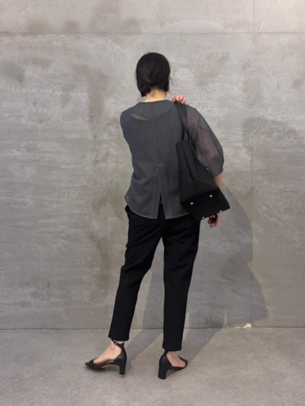 ブラック系のその他パンツ、グレー系のシャツ/ブラウス、ブラック系のトートバッグを着用したレディースの春コーディネートの6枚目の写真