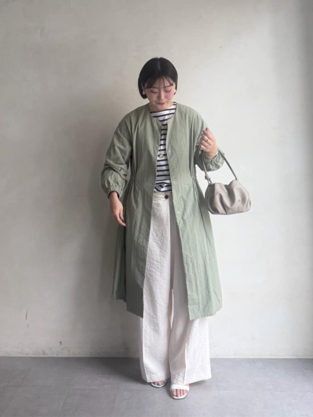 グリーン系のその他アウター、ホワイト系のその他パンツ、ホワイト系のTシャツ/カットソーを着用したレディースの冬コーディネートの2枚目の写真