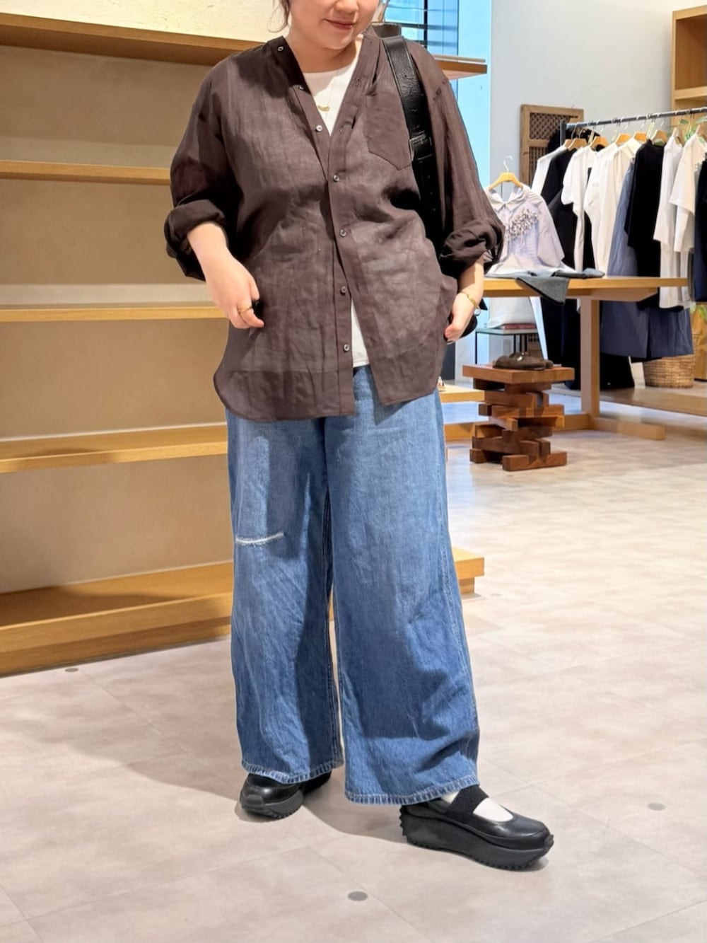 ブルー系のその他パンツ、ブラック系のスニーカー、ブラウン系のシャツ/ブラウスを着用したレディースの春コーディネートの7枚目の写真
