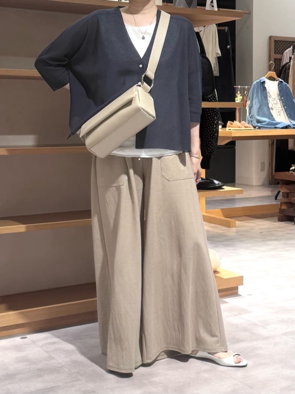 ベージュ系のその他パンツ、ベージュ系のショルダーバッグ、ブルー系のカーディガン/ボレロを着用したレディースの春コーディネートの3枚目の写真