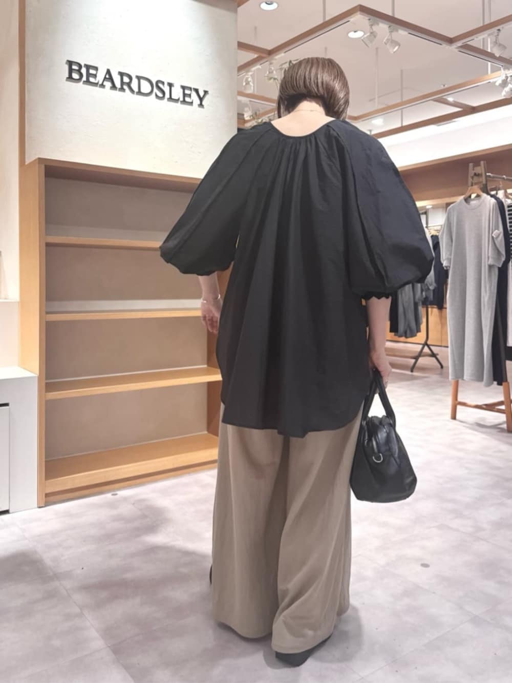 ブラック系のボストンバッグ、ベージュ系のその他パンツ、ブラック系のシャツ/ブラウスを着用したレディースの春コーディネートの4枚目の写真