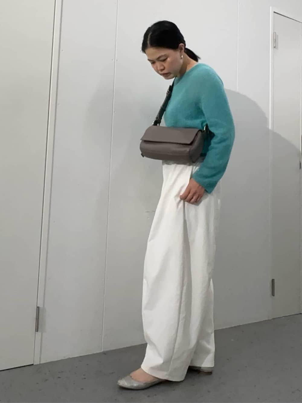 グレー系のショルダーバッグ、ブルー系のニット/セーター、ホワイト系のその他パンツを着用したレディースの夏コーディネートの5枚目の写真