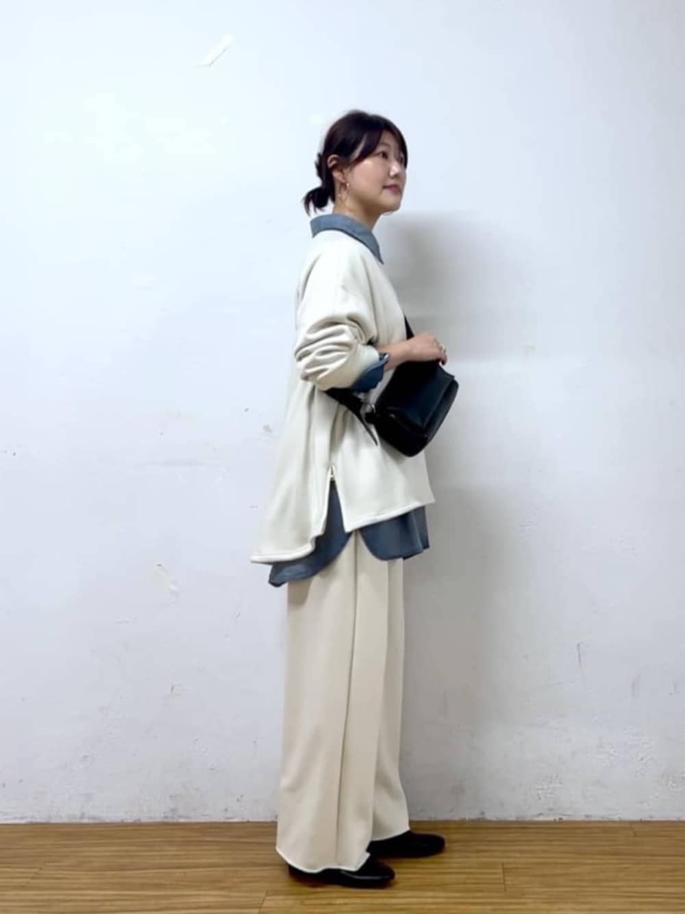 ブルー系のシャツ/ブラウス、ブラック系のショルダーバッグ、ホワイト系のTシャツ/カットソーを着用したレディースの秋コーディネートの6枚目の写真