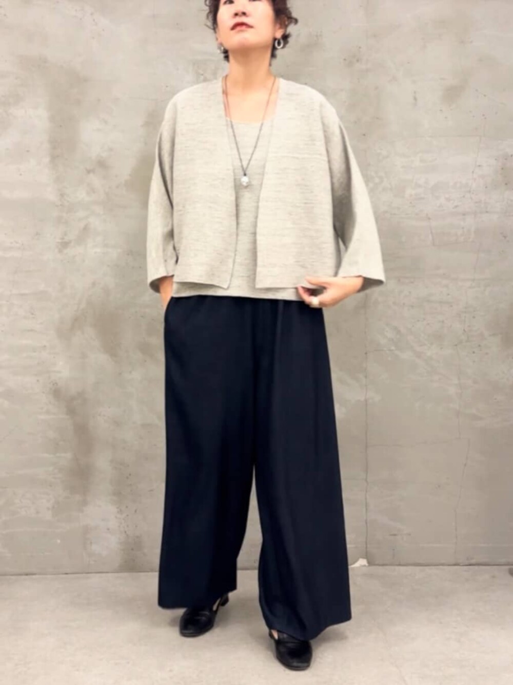 ブルー系のその他パンツ、グレー系のニット/セーター、グレー系のカーディガン/ボレロを着用したレディースの春コーディネートの5枚目の写真