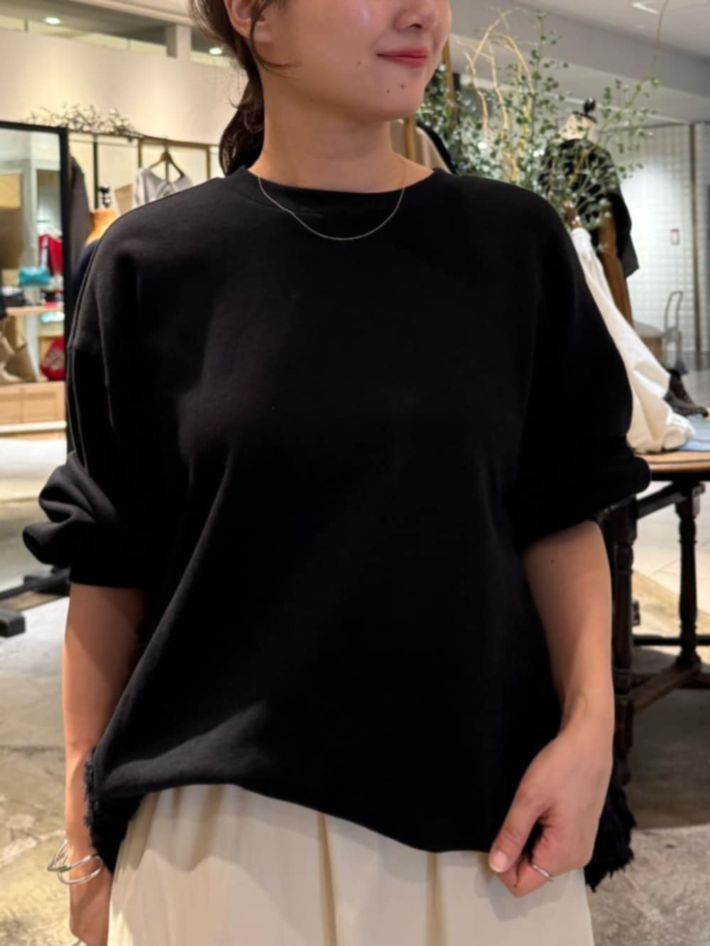 ベージュ系のスカート、ブラック系のTシャツ/カットソーを着用したレディースの秋コーディネートの4枚目の写真