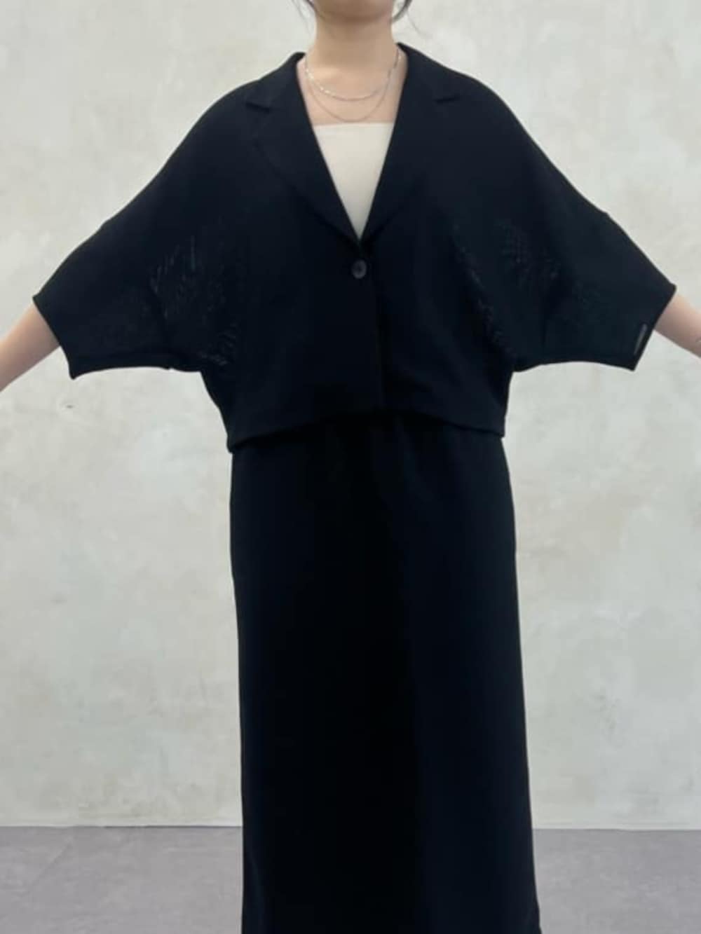 グレー系のハンドバッグ、ブラック系のテーラードジャケット、ブラック系のスカートを着用したレディースの春コーディネートの5枚目の写真