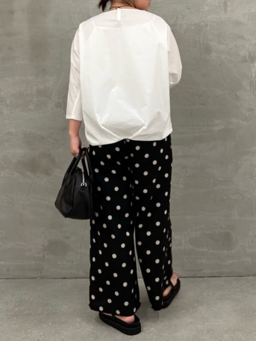 ブラック系のボストンバッグ、ホワイト系のシャツ/ブラウス、ブラック系のその他パンツを着用したレディースの冬コーディネートの4枚目の写真