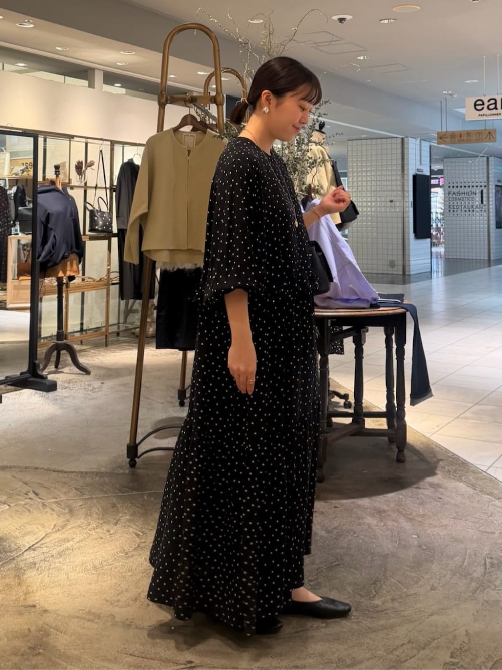 ブラック系のハンドバッグ、ブラック系のワンピースを着用したレディースの春コーディネートの4枚目の写真