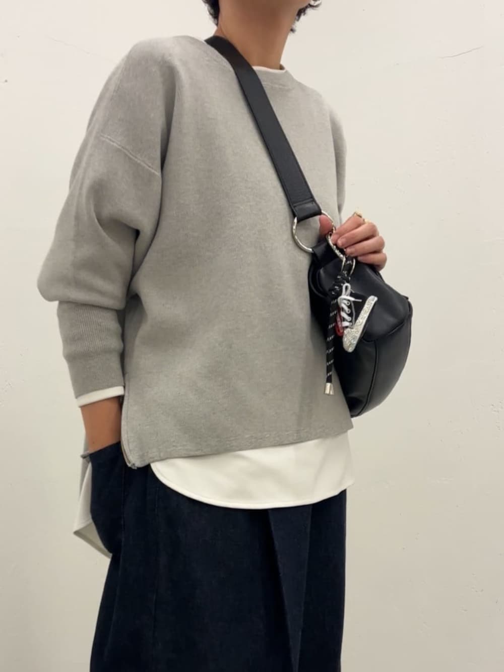 ブラック系のチャームを着用したレディースの冬コーディネートの2枚目の写真