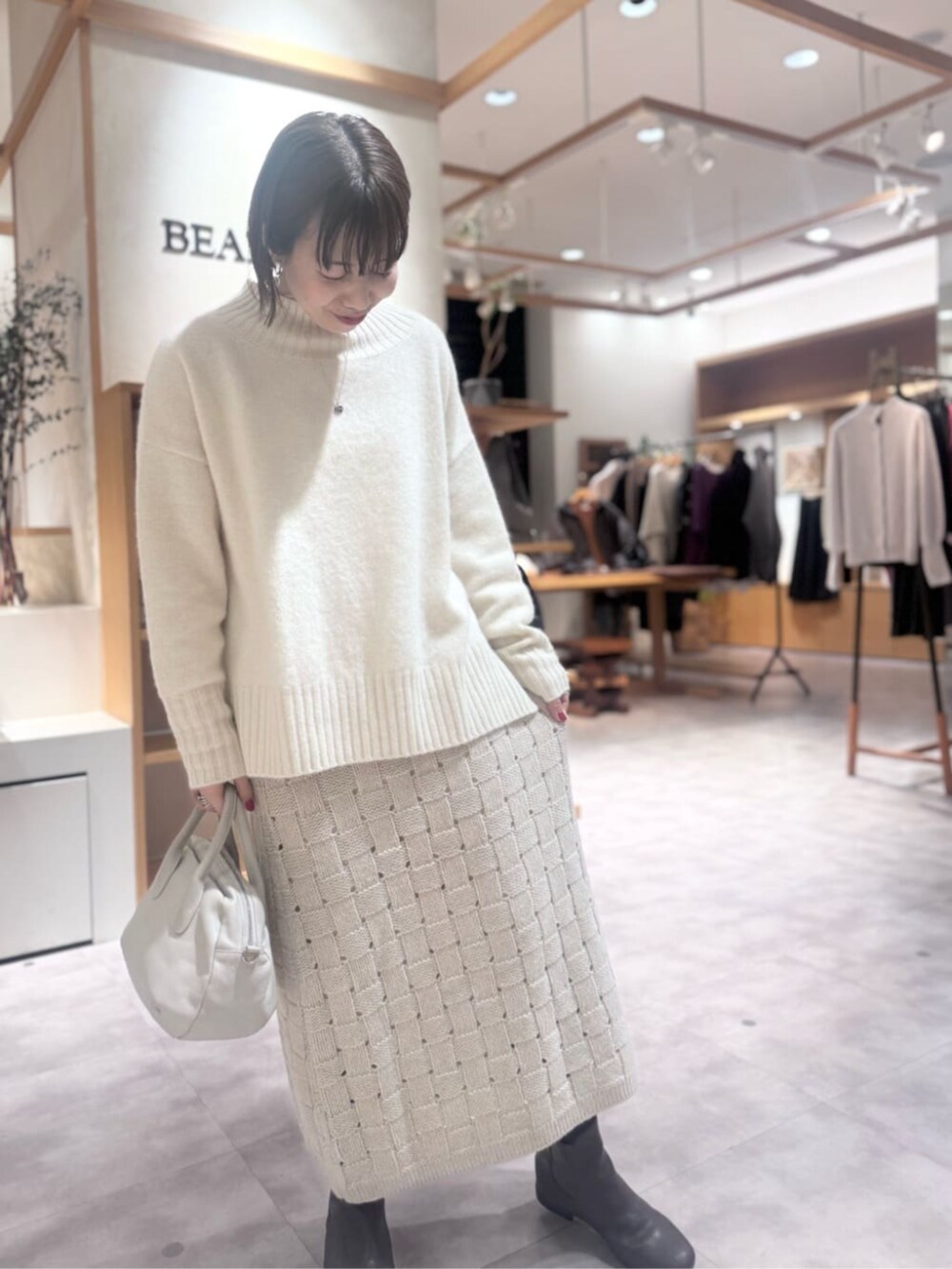 グレー系のボストンバッグ、ベージュ系のスカート、ブラウン系のダウンジャケット/コートを着用したレディースの冬コーディネートの8枚目の写真