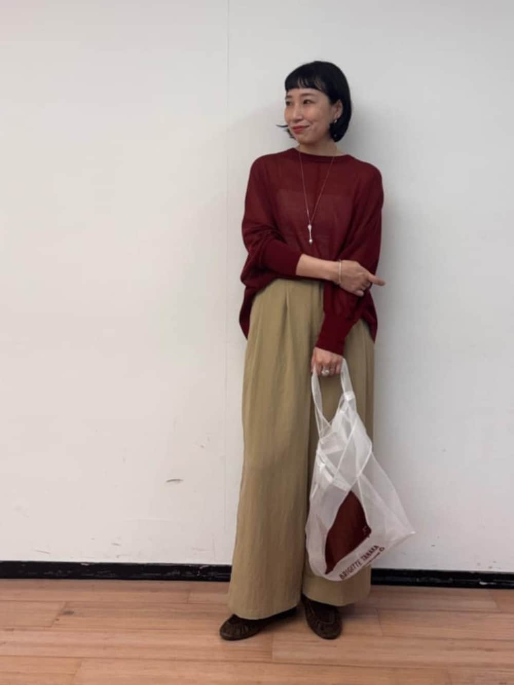 レッド系のニット/セーター、イエロー系のその他パンツ、ブラウン系のその他シューズを着用したレディースの夏コーディネートの2枚目の写真