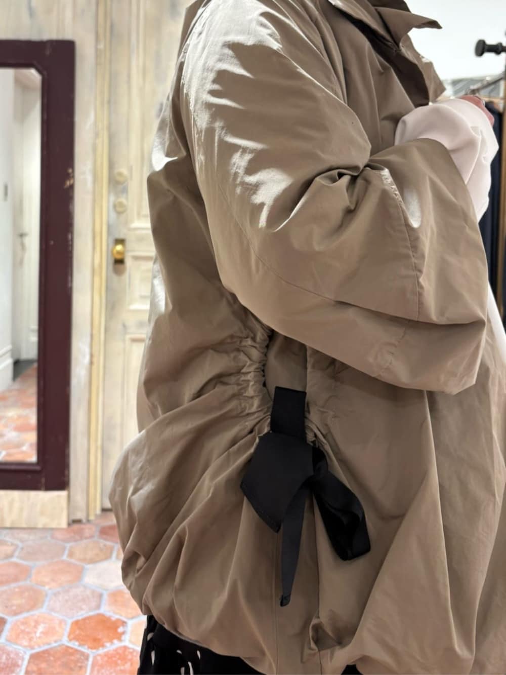 グリーン系のハンドバッグ、ブラック系のスカート、ブラウン系のブルゾンを着用したレディースの冬コーディネートの5枚目の写真