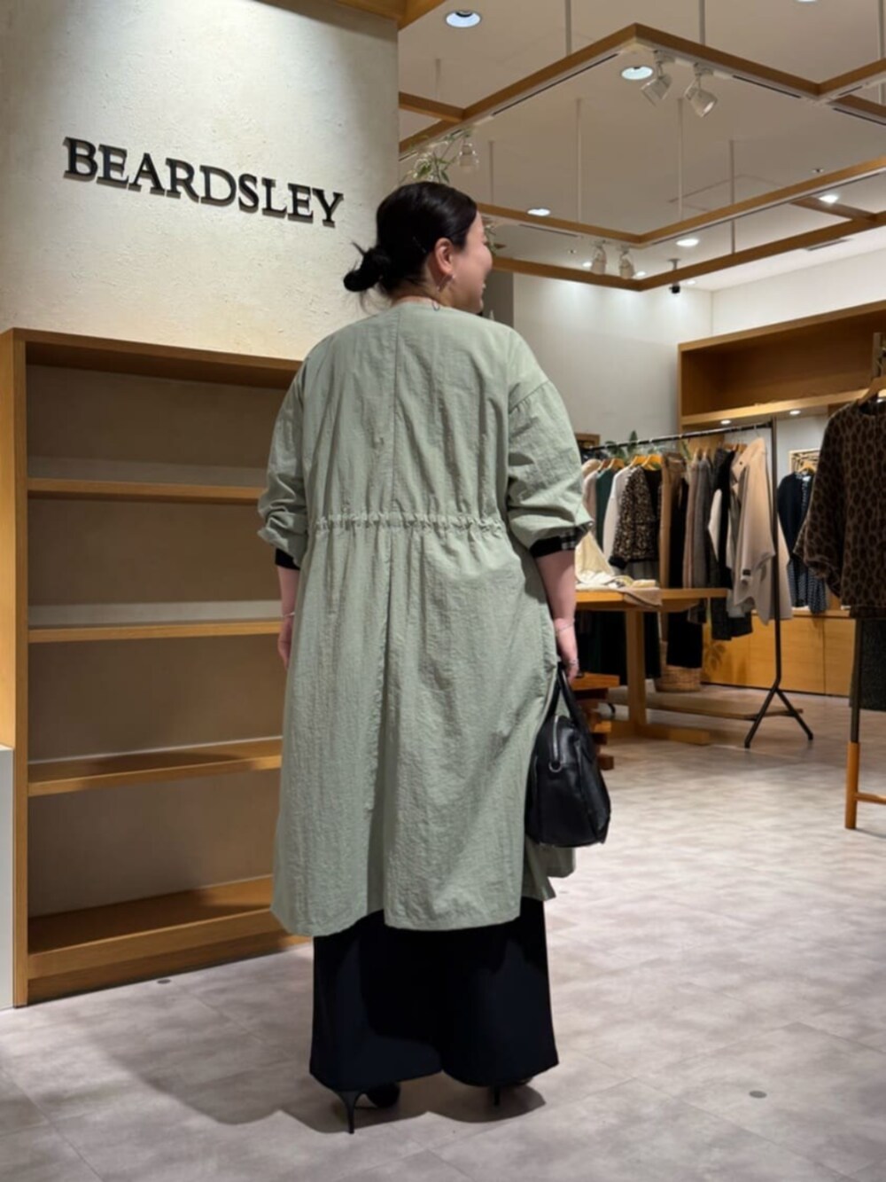 ブラック系のその他パンツ、ブラック系のシャツ/ブラウス、グリーン系のその他アウターを着用したレディースの冬コーディネートの3枚目の写真