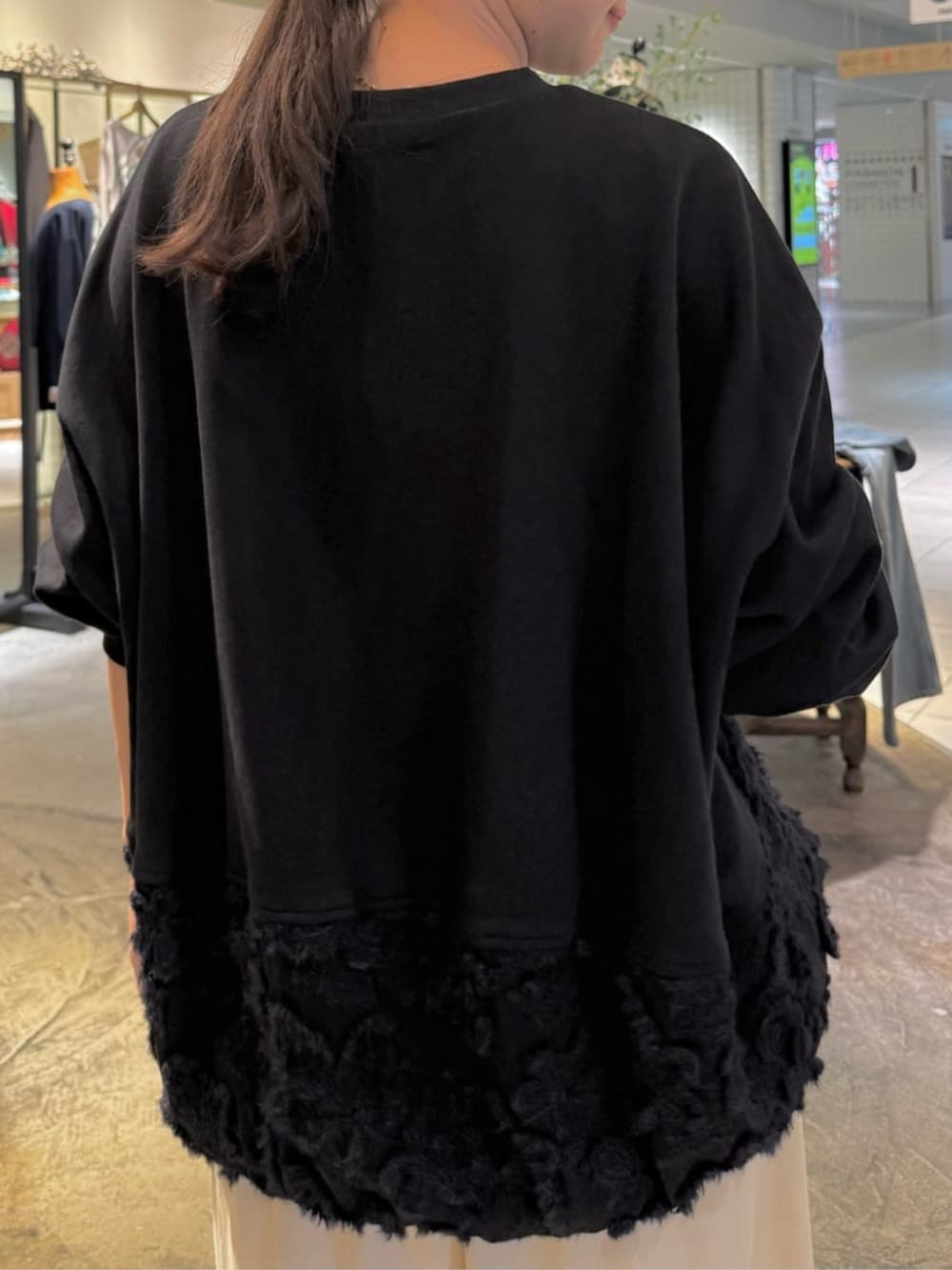 ブラック系のトートバッグ、ベージュ系のスカート、ブラック系のTシャツ/カットソーを着用したレディースの秋コーディネートの2枚目の写真