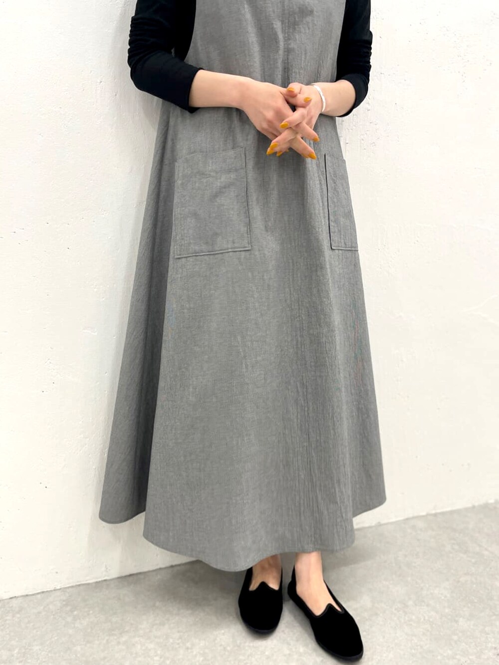 グレー系のワンピース、ブラック系のTシャツ/カットソーを着用したレディースの春コーディネートの3枚目の写真