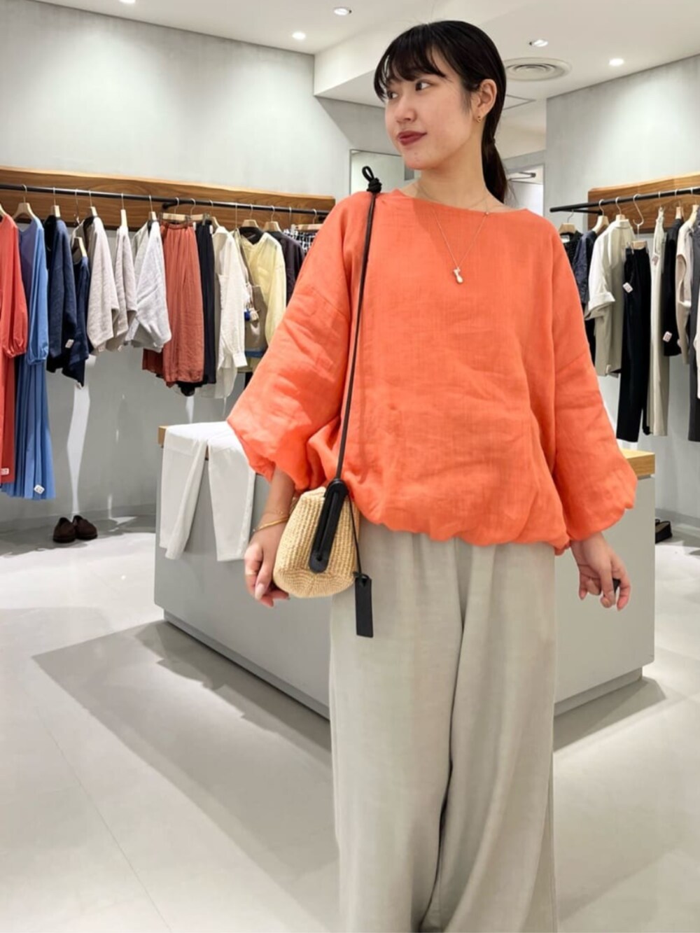 グレー系のその他パンツ、オレンジ系のシャツ/ブラウスを着用したレディースの春コーディネートの7枚目の写真