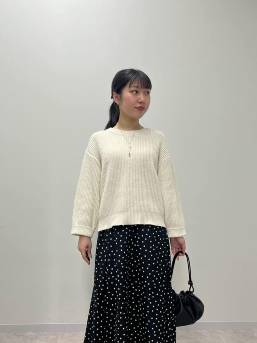 ブラック系のスカート、ホワイト系のニット/セーターを着用したレディースの冬コーディネートの4枚目の写真