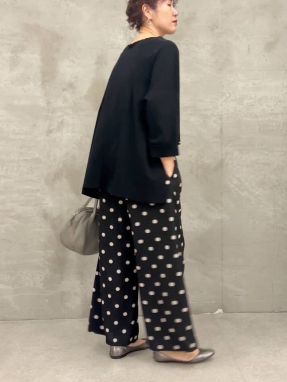 グレー系のボストンバッグ、ブラック系のTシャツ/カットソー、ブラック系のその他パンツを着用したレディースの春コーディネートの2枚目の写真