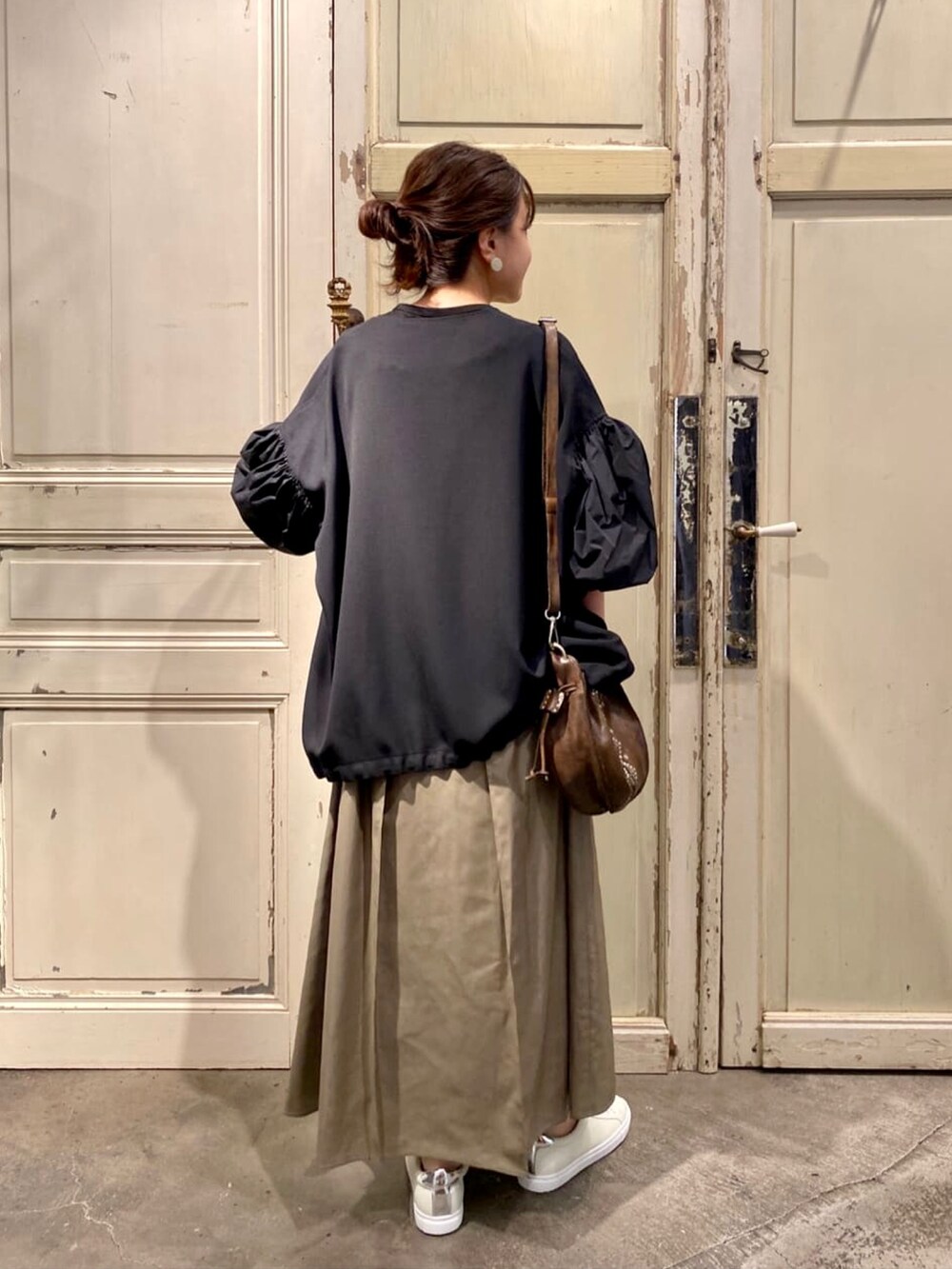 グリーン系のスカート、グリーン系のショルダーバッグを着用したレディースの秋コーディネートの3枚目の写真