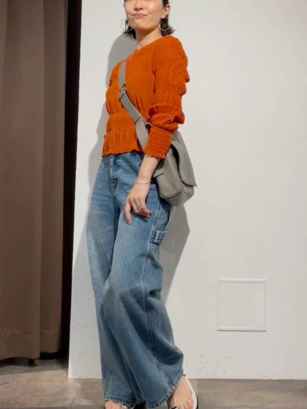 オレンジ系のシャツ/ブラウス、ブルー系のその他パンツ、ホワイト系のサンダルを着用したレディースの春コーディネートの4枚目の写真