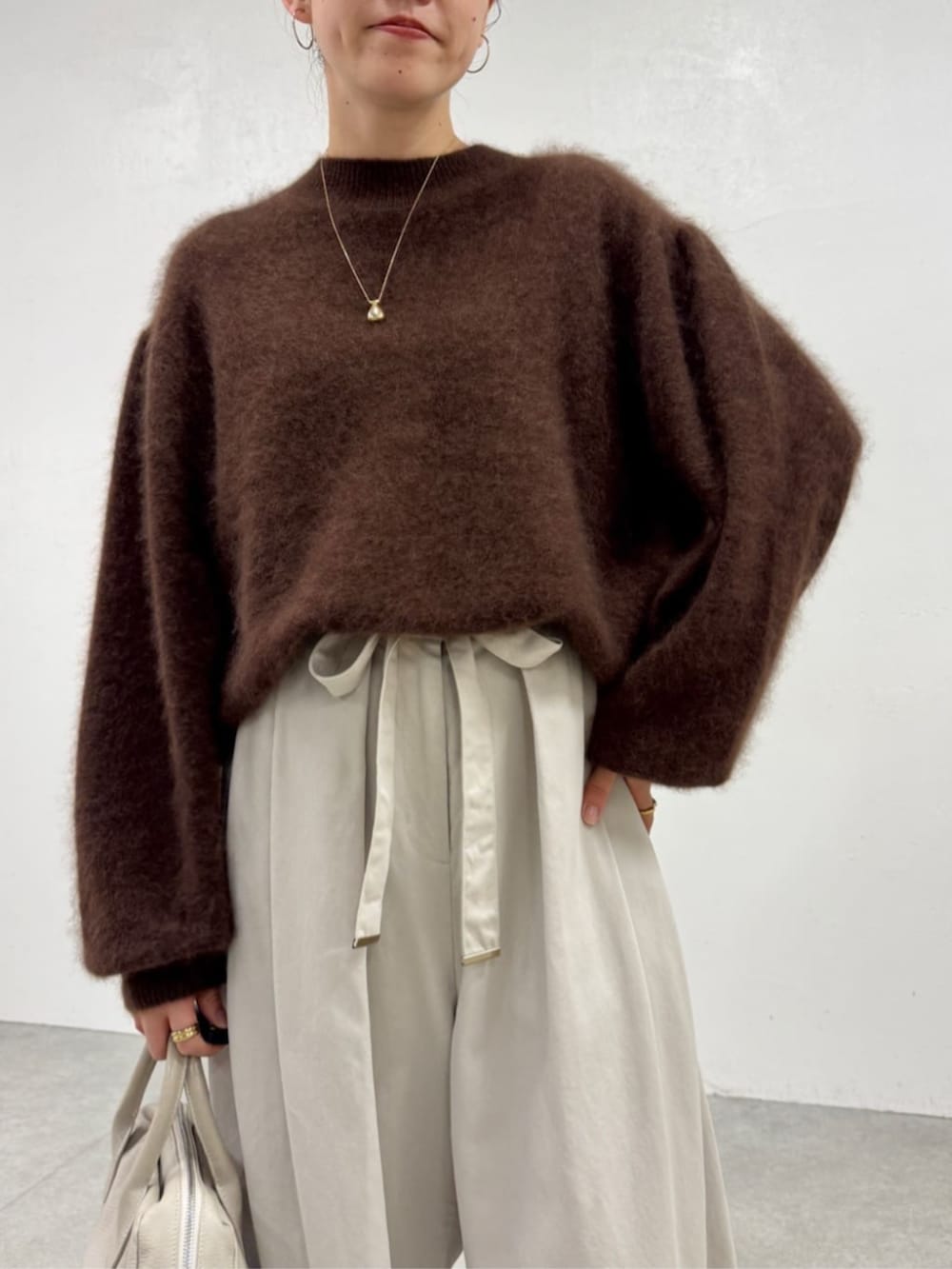 ブラック系のローファー、ホワイト系のその他パンツ、ブラウン系のニット/セーターを着用したレディースの秋コーディネートの3枚目の写真