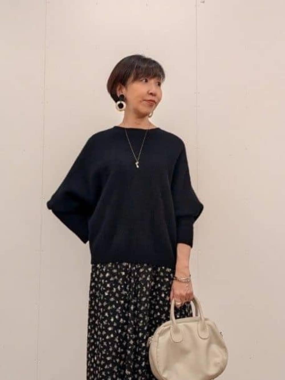 ブラック系のスカート、ブラック系のブーツ、グレー系のその他アウターを着用したレディースの秋コーディネートの8枚目の写真