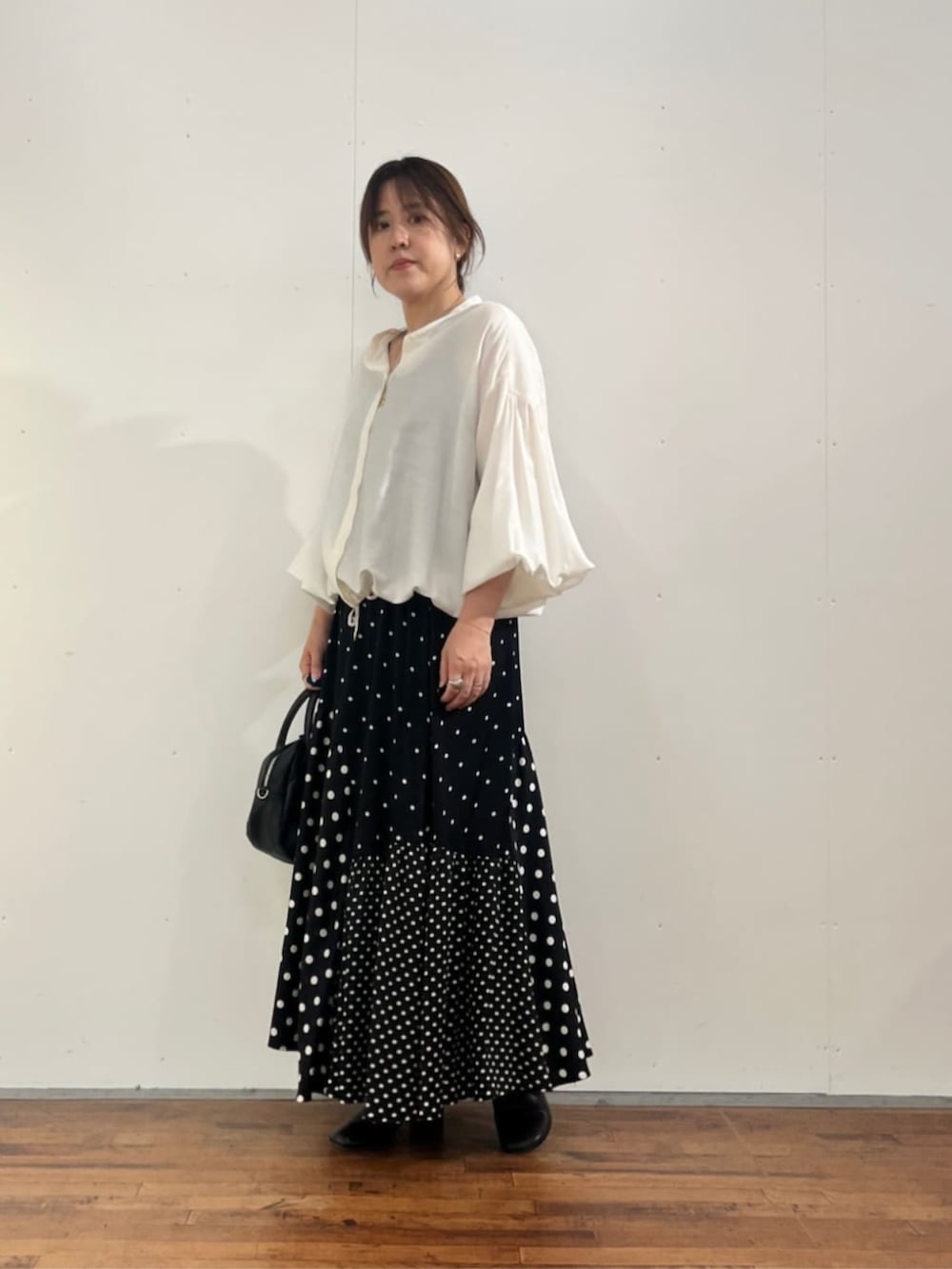 ブラック系のスカート、ホワイト系のシャツ/ブラウスを着用したレディースの夏コーディネートの7枚目の写真