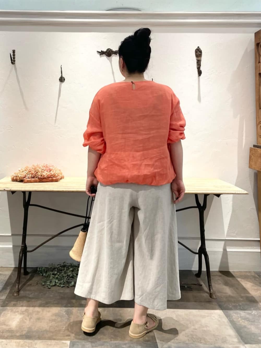 ベージュ系のその他パンツ、オレンジ系のシャツ/ブラウス、ゴールド系のリングを着用したレディースの春コーディネートの6枚目の写真