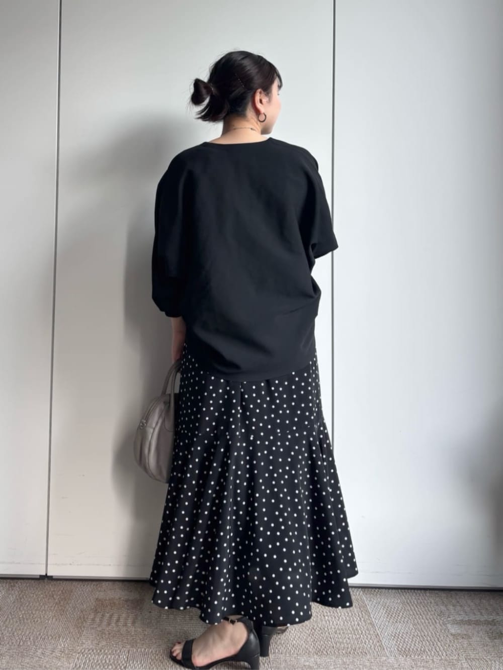 ブラック系のカーディガン/ボレロ、グレー系のボストンバッグ、ブラック系のスカートを着用したレディースの冬コーディネートの3枚目の写真