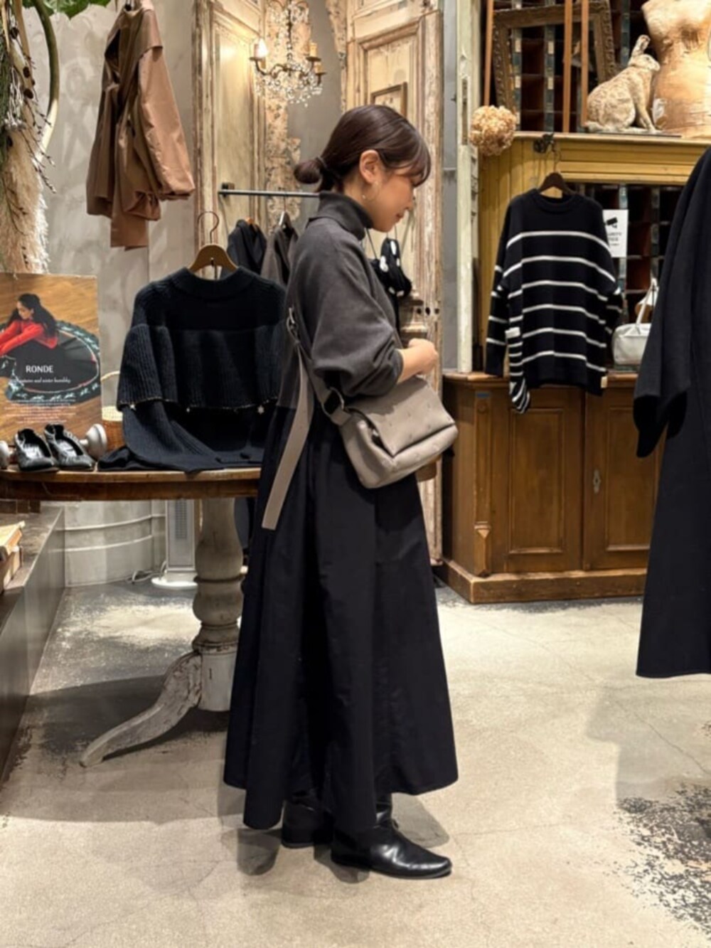 グレー系のワンピース、グレー系のショルダーバッグを着用したレディースの冬コーディネートの4枚目の写真