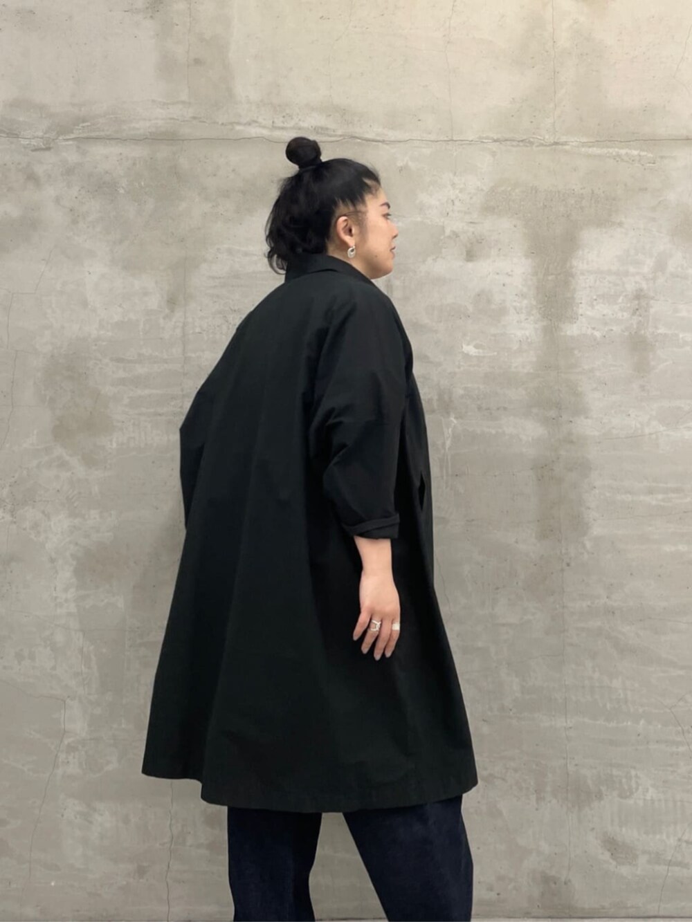 ホワイト系のトートバッグ、ブルー系のデニムパンツ、ブラック系のその他アウターを着用したレディースの冬コーディネートの6枚目の写真