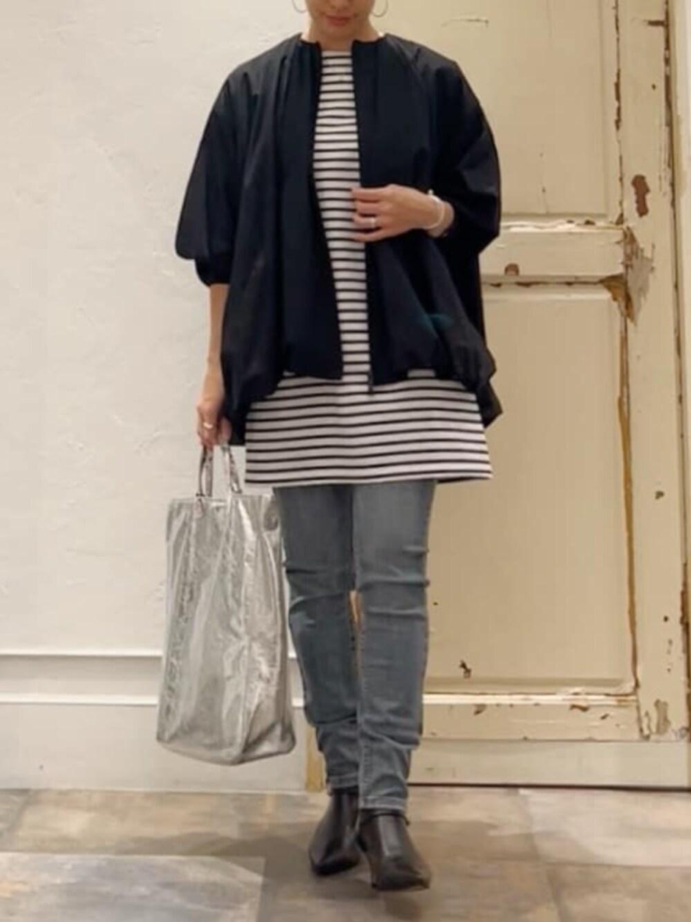 ブルー系のデニムパンツ、ブルー系のTシャツ/カットソー、ブラック系のトートバッグを着用したレディースの冬コーディネートの4枚目の写真