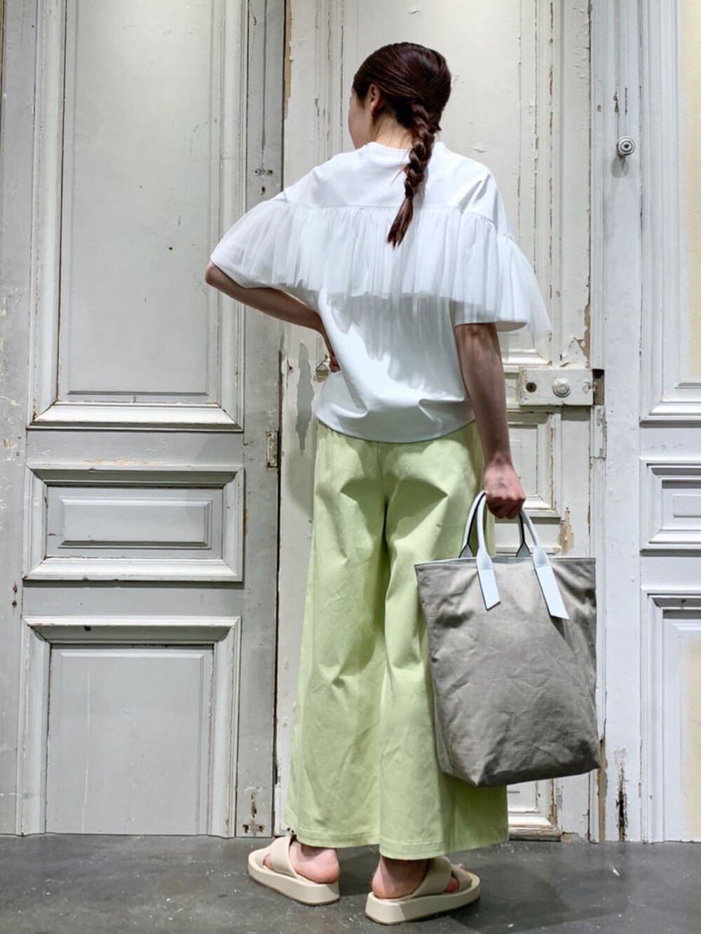 ホワイト系のTシャツ/カットソー、イエロー系のその他パンツ、ホワイト系のトートバッグを着用したレディースの春コーディネートの2枚目の写真