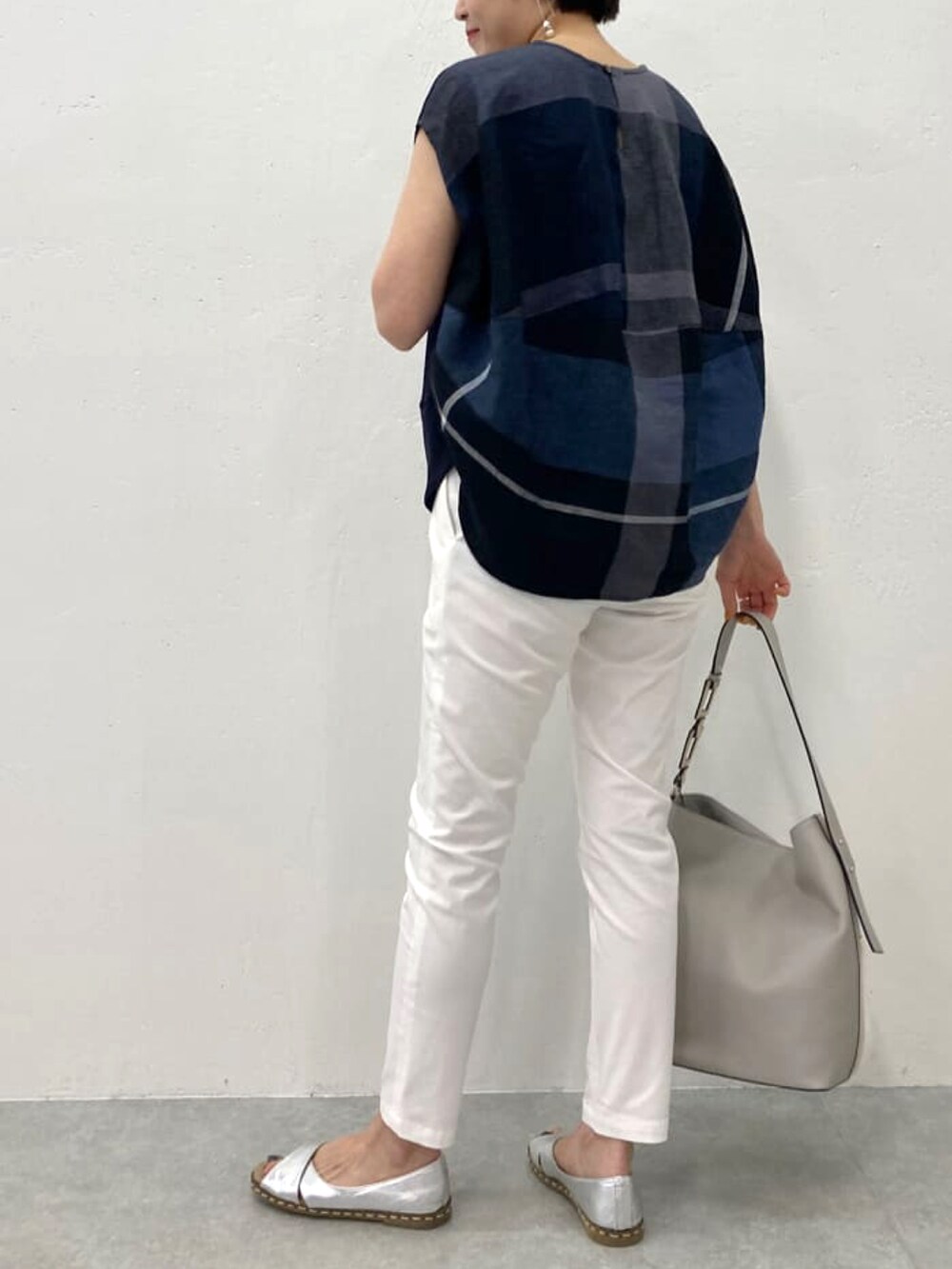 ブルー系のTシャツ/カットソー、ホワイト系のその他パンツ、グレー系のトートバッグを着用したレディースの春コーディネートの2枚目の写真