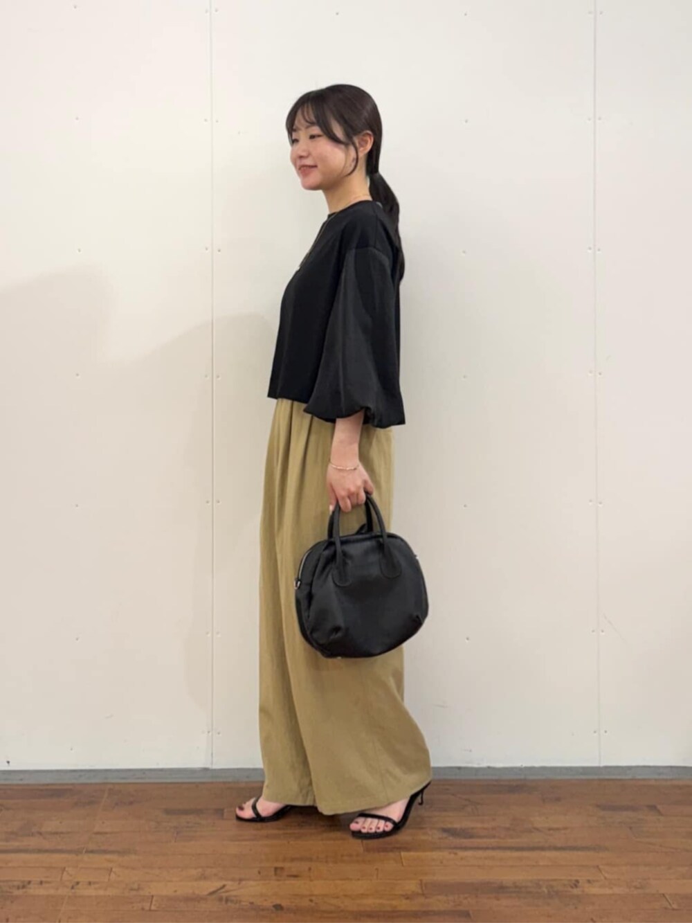 イエロー系のその他パンツ、ブラック系のTシャツ/カットソーを着用したレディースの夏コーディネートの2枚目の写真
