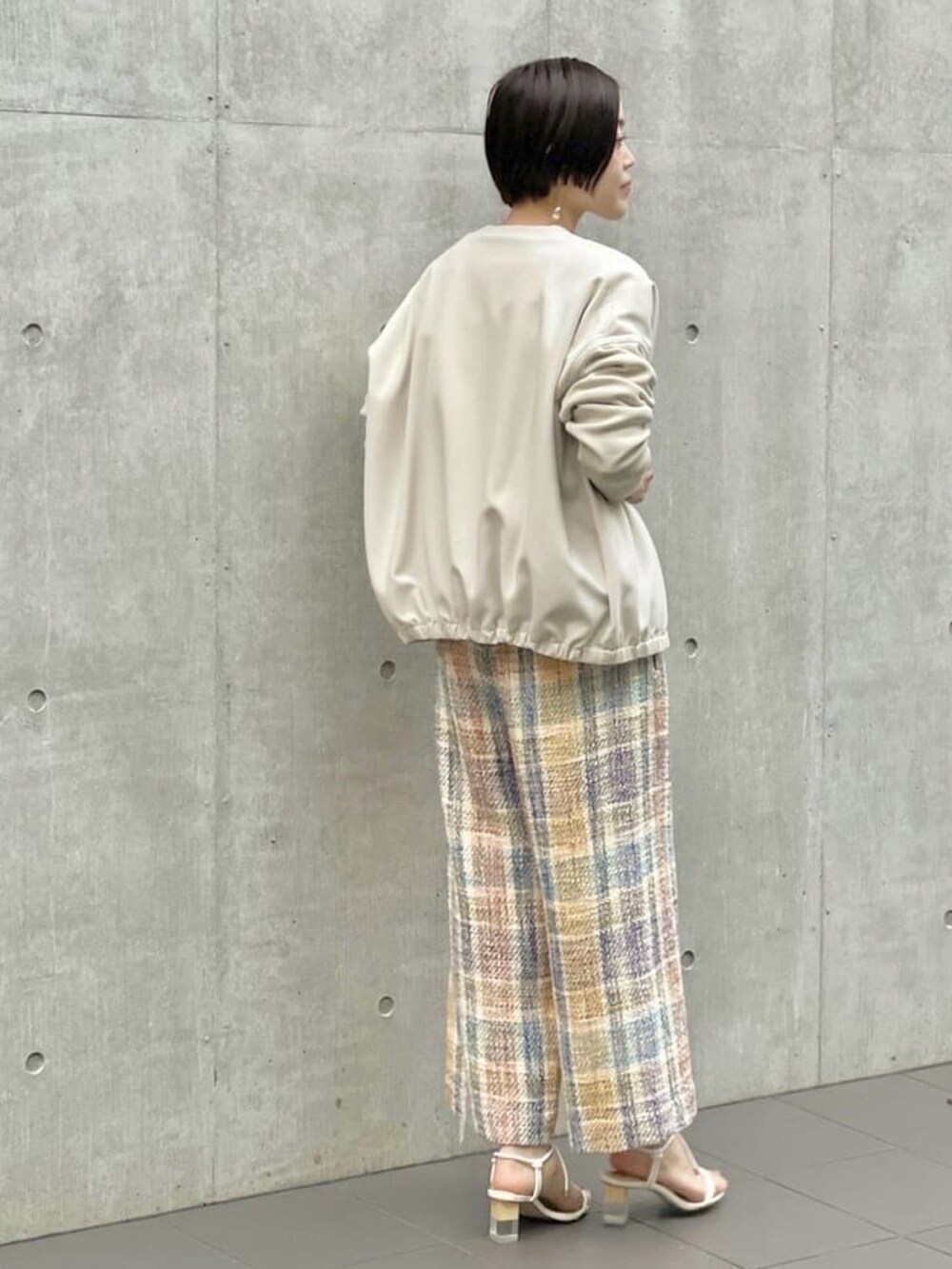 ホワイト系のノーカラージャケット、ブルー系のその他パンツを着用したレディースの春コーディネートの2枚目の写真