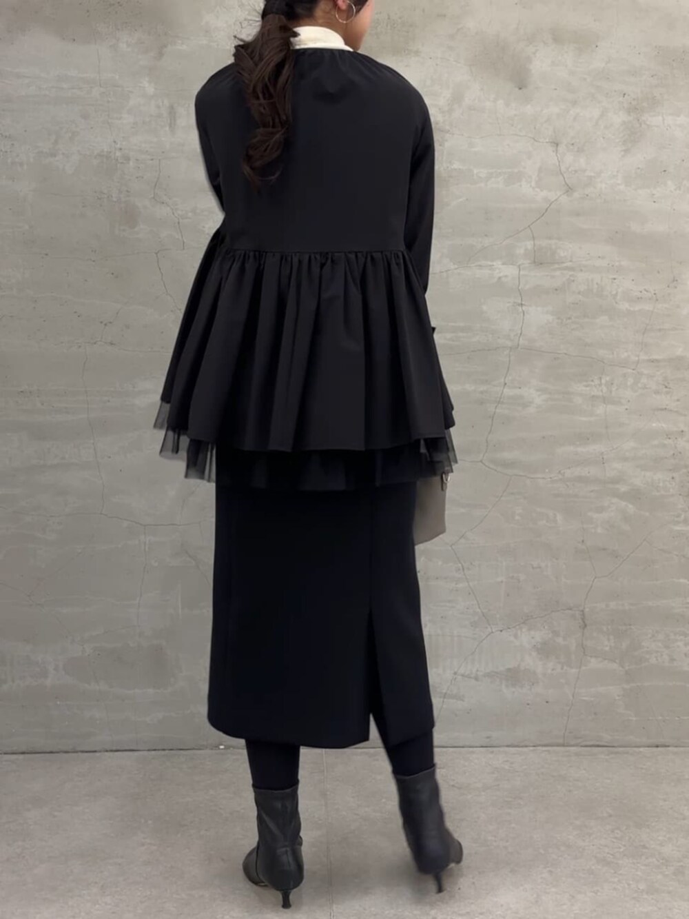 ブラック系のスカート、ブラック系のブルゾンを着用したレディースの冬コーディネートの5枚目の写真