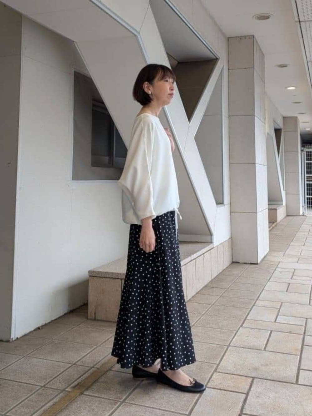 ブラック系のスカート、ホワイト系のシャツ/ブラウスを着用したレディースの冬コーディネートの2枚目の写真