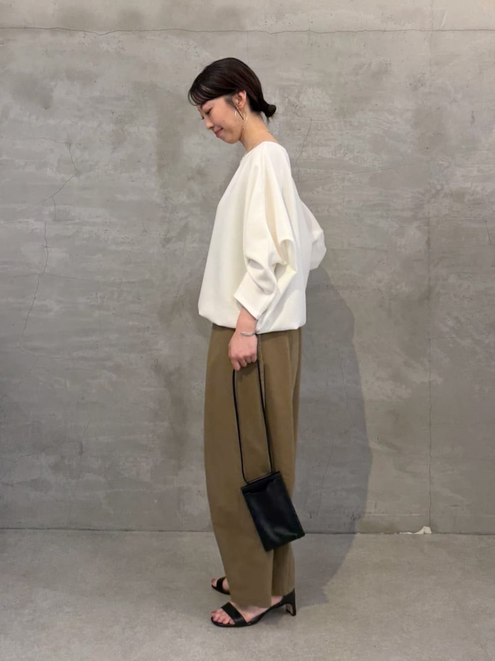 ブラック系のショルダーバッグ、ホワイト系のシャツ/ブラウス、イエロー系のその他パンツを着用したレディースの春コーディネートの2枚目の写真